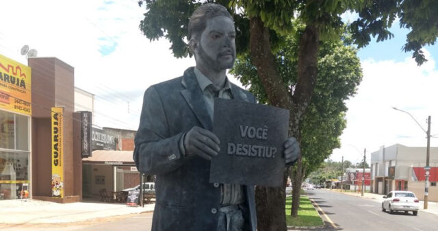 VOCÊ DESISTIU? Pergunta que está em uma placa exposta por uma"estátua viva" em frente a escola SENAI