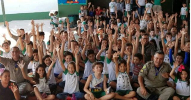 Integrantes do Núcleo de Polícia Comunitária do 18° BPM participam de homenagens voltadas ao dia do soldado, em uma Escola de Catalão