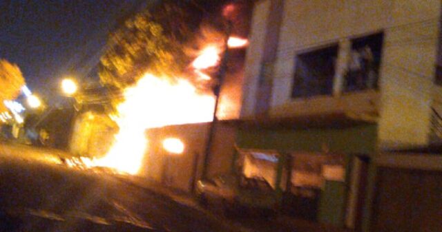 Bombeiros combatem incêndio em residência, no local funcionava uma oficina mecânica