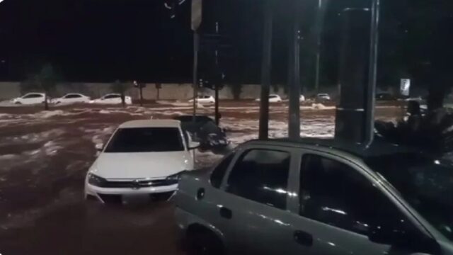 Enxurrada quase encobre carros na Avenida Rondon Pacheco durante temporal em Uberlândia