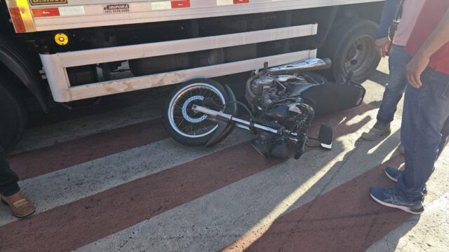 Motociclista de 28 anos fica ferida após colisão com carro e cair parcialmente debaixo de caminhão em rotatória no centro de Catalão